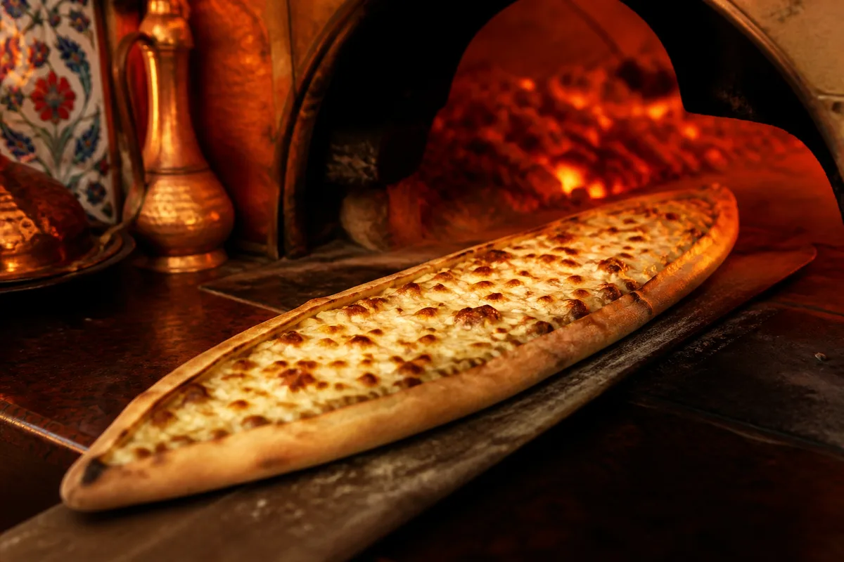 Pide sortant du four, forme allongée en barque garnie de fromage fondu